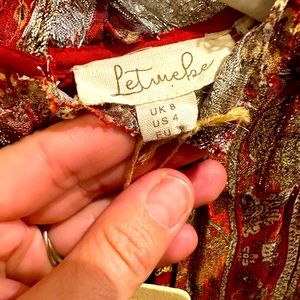 Capped sleeve blouse with ruffle detail. Metallic floral print. Fully lined. NWT